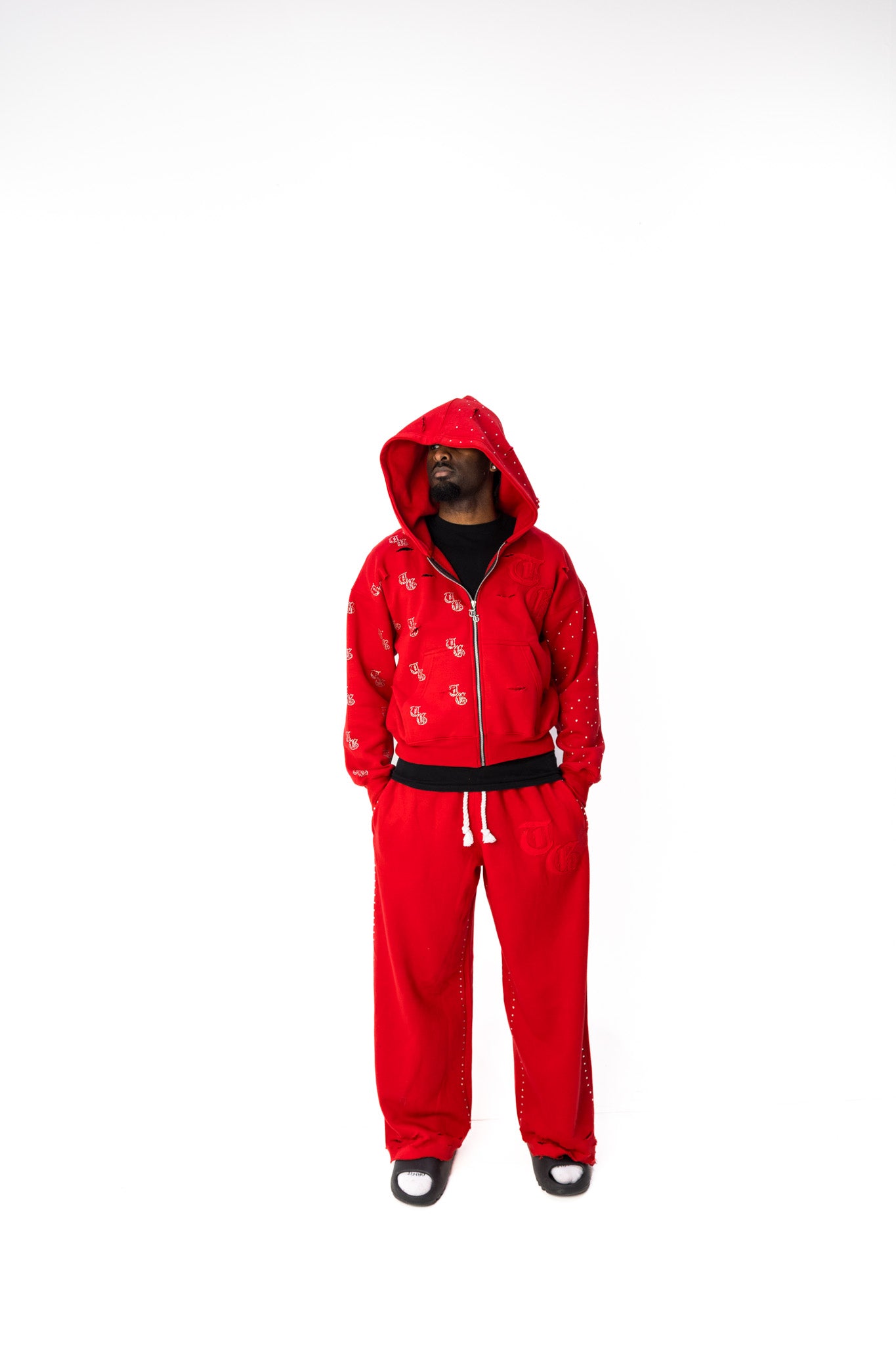 Red front model view of TG Rhinestone oversized, distressed rhinestone sweatpants. 