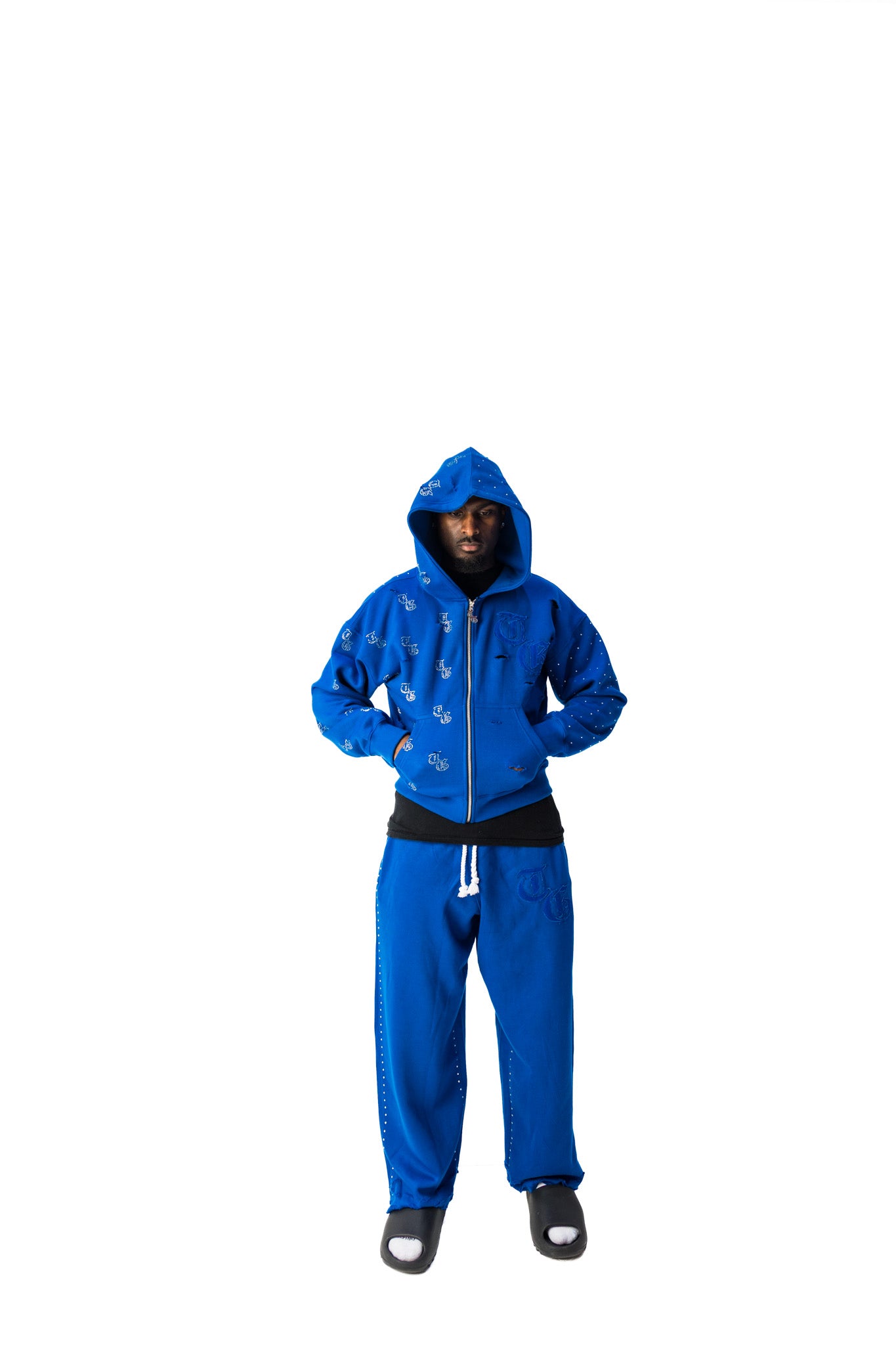 Blue model front view of TG Rhinestone oversized, distressed rhinestone sweatpants and jacket. 