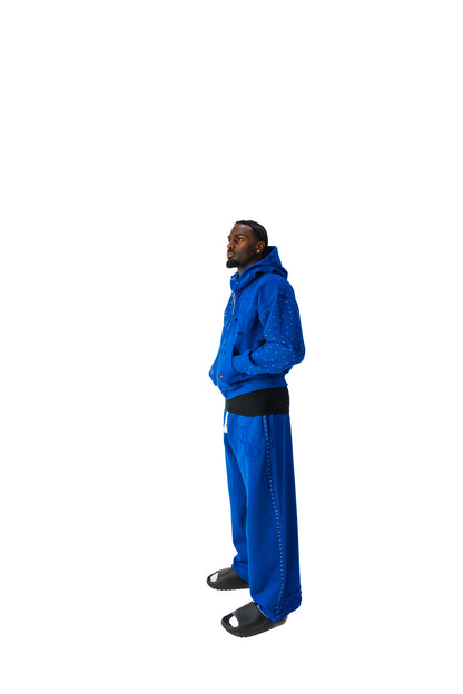 Blue side view of TG Rhinestone oversized, distressed rhinestone sweatpants. 