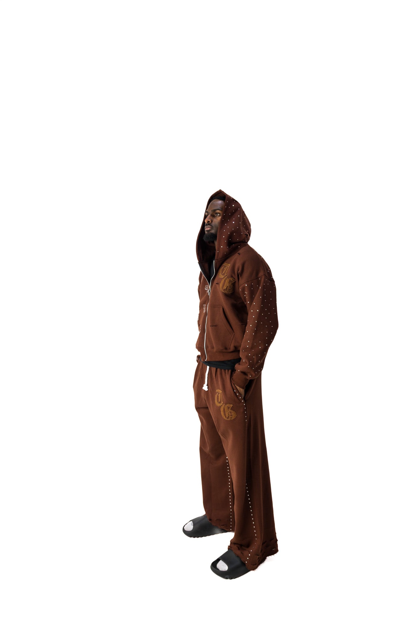 Brown model side view of TG Rhinestone oversized, distressed rhinestone sweatpants and jacket. 