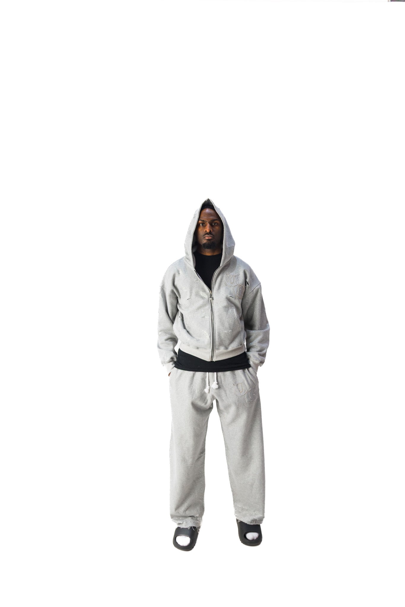Gray model front view of TG Rhinestone oversized, distressed rhinestone sweatpants. 